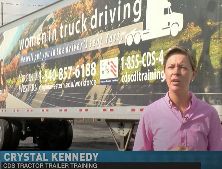 image of Crystal Kennedy standing in front of Women in trucking branded CDS truck