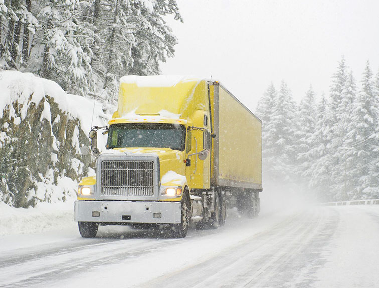 Image of semi truck driving through the snow