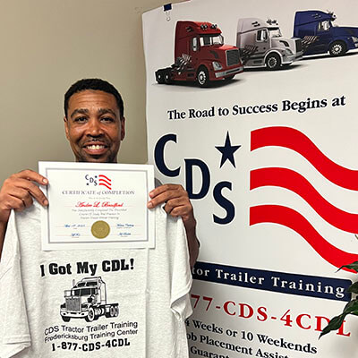 Image of CDS grad, Andre Bradford, posing with his certificate