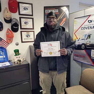 Image of CDS grad, Jahkem Shelby, posing with his certificate