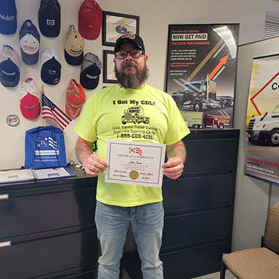 Image of CDS grad, John James, posing with his certificate