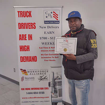 Image of CDS grad, Kevin Phillips, posing with his certificate