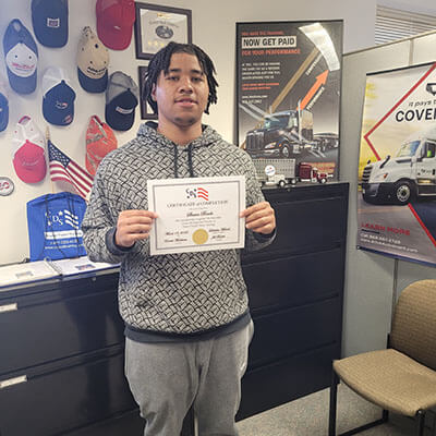 Image of CDS grad, Shawn Banks, posing with his certificate