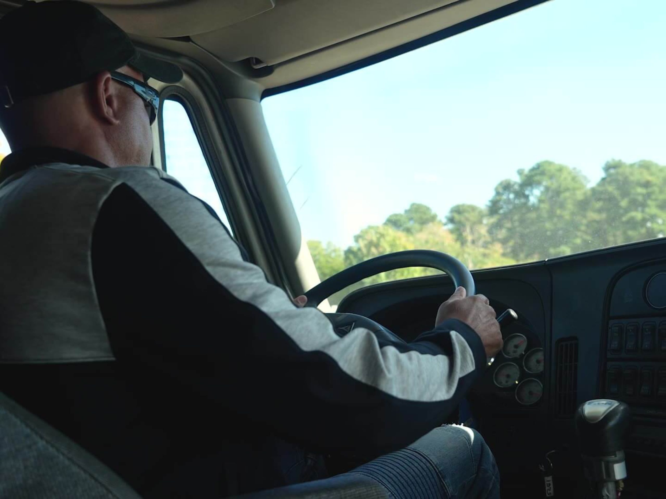 image of a semi-truck driver in the cab of his vehicle